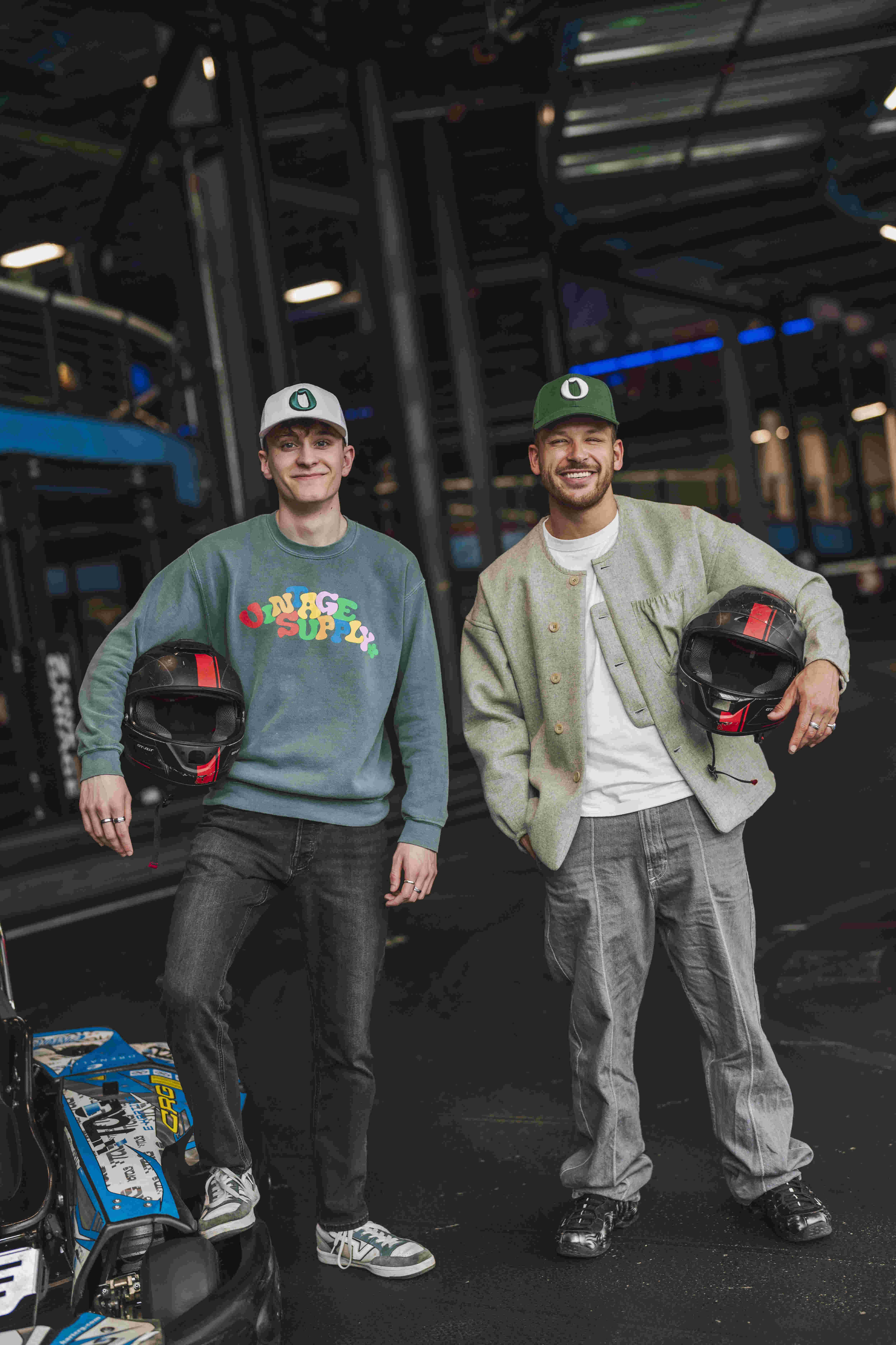 Benjamin et PtitTom se tiennent debout l'un à côté de l'autre avec un casque de moto dans les mains